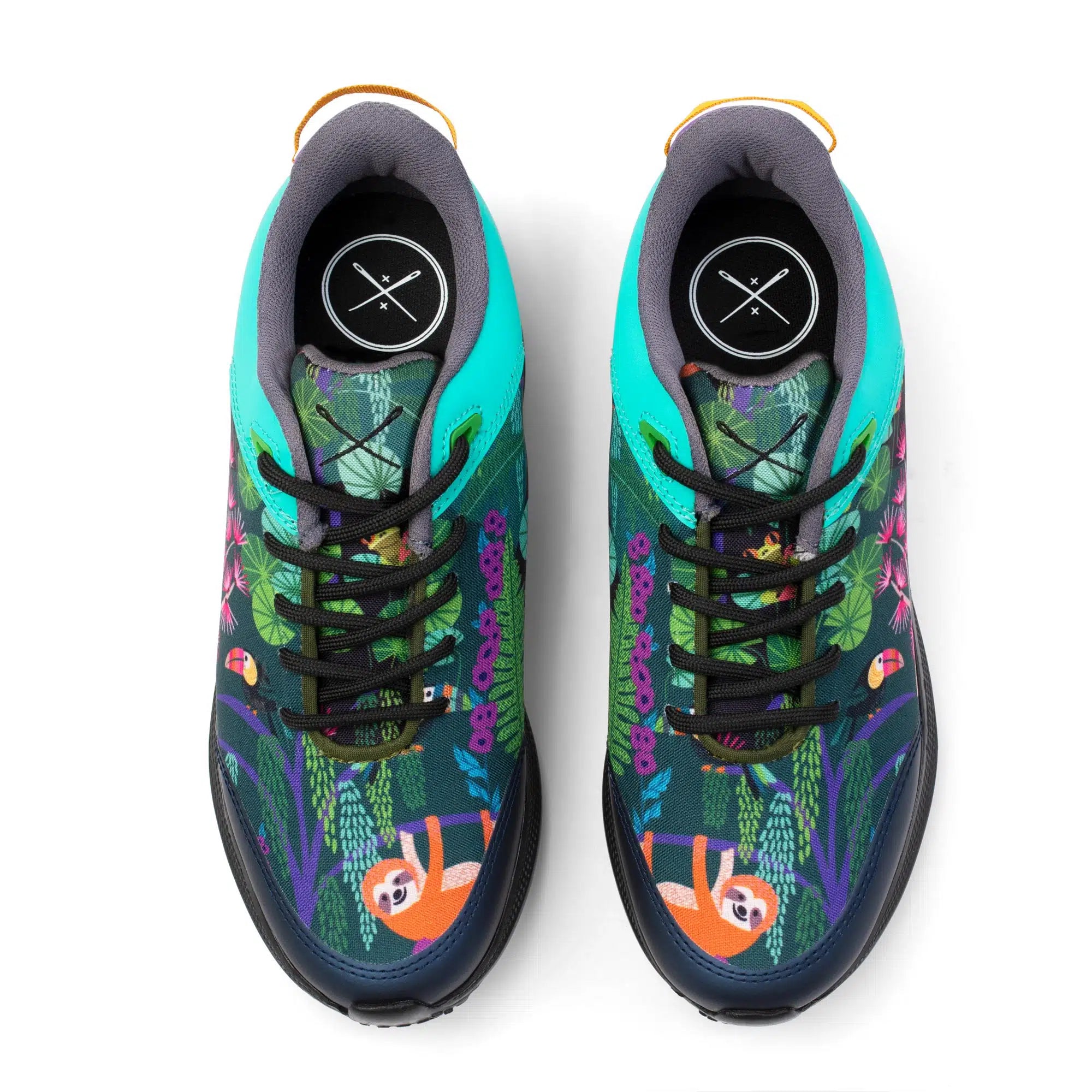 A pair of low-top sneakers shown from a top-down view on a white background. The shoes feature a dark navy base with a colorful tropical jungle print including green leaves, purple vines, and orange sloths, with bright turquoise side panels and black laces.