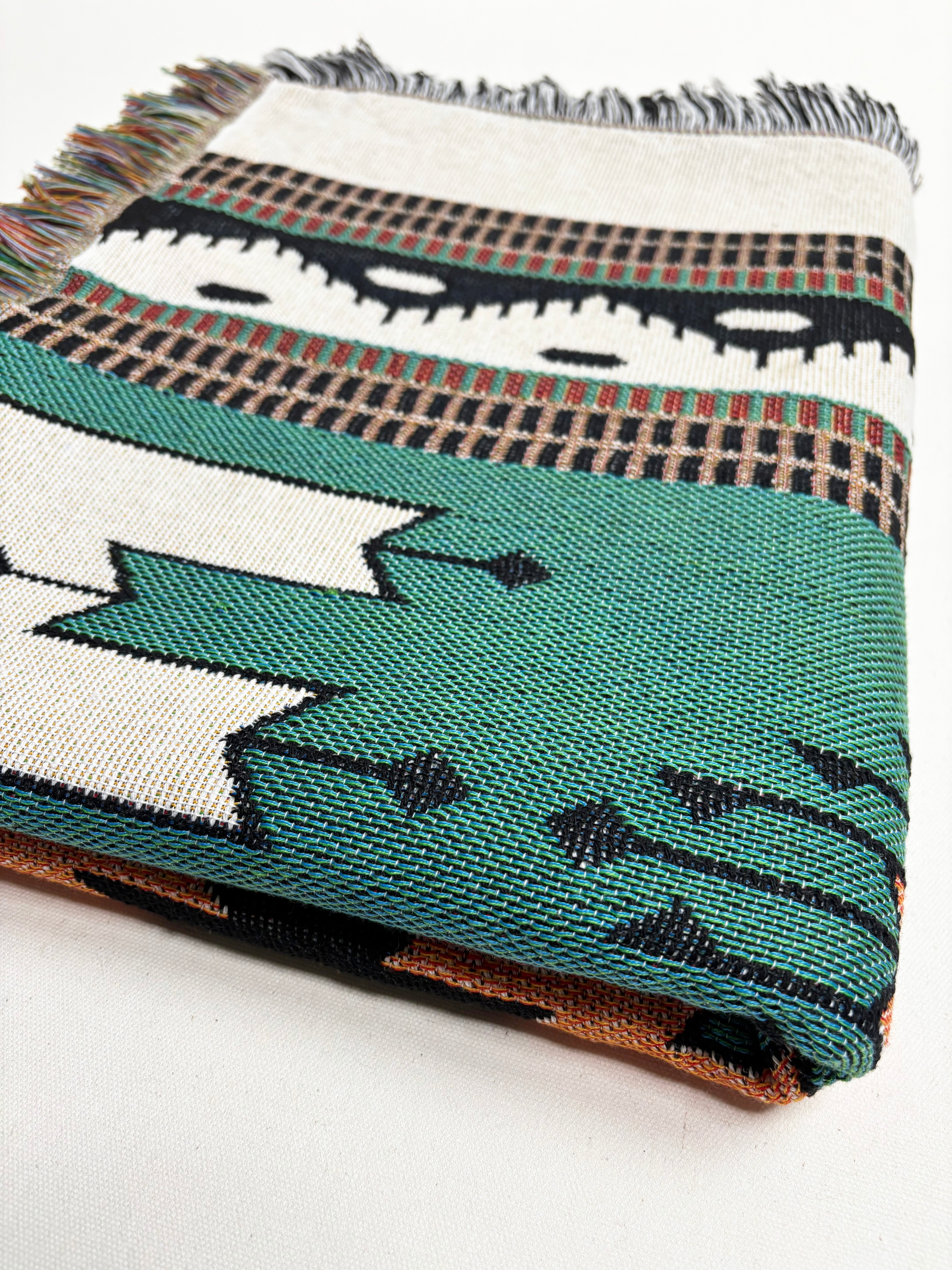 Woven blanket with geometric pattern on a white background