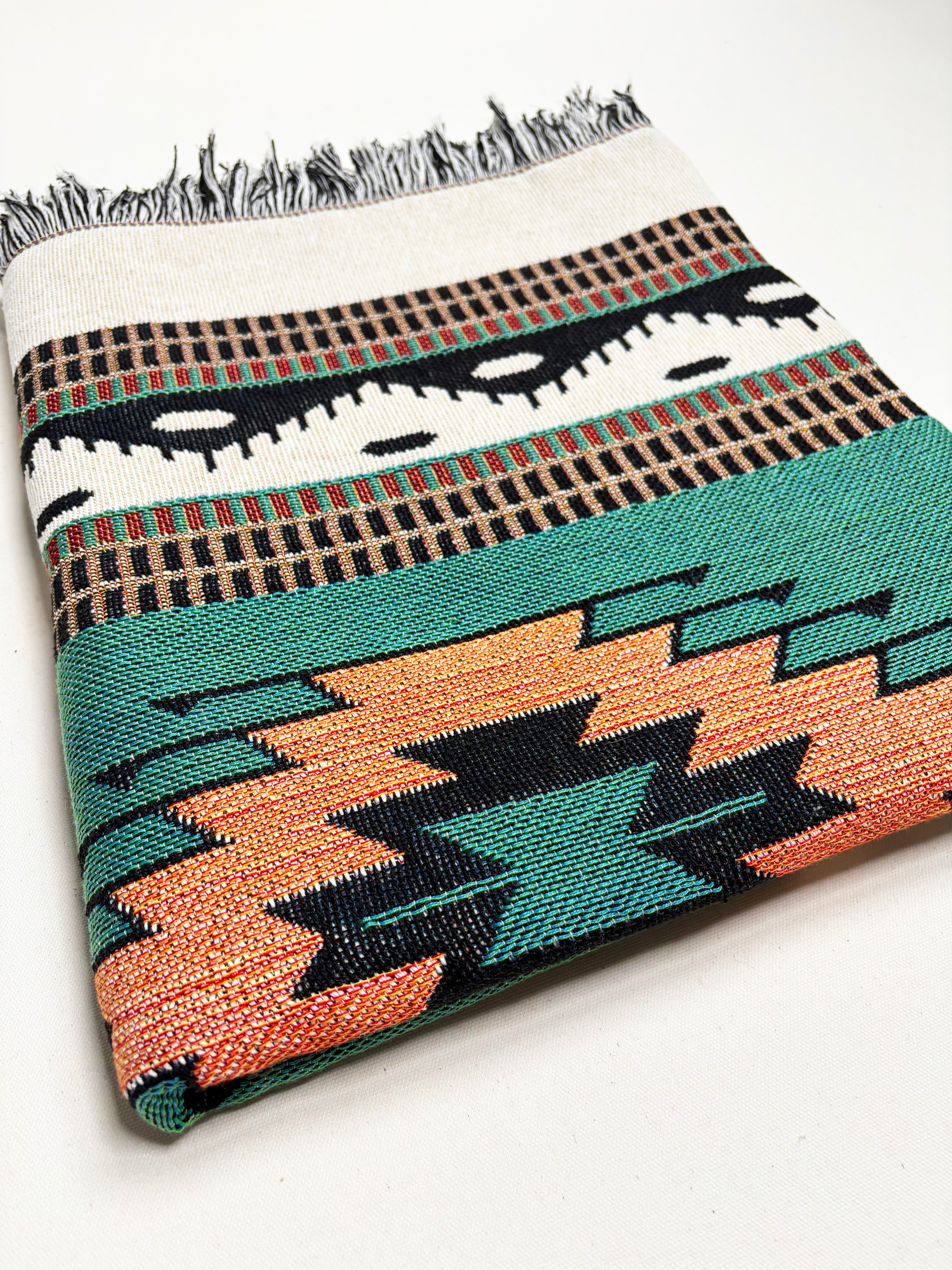 Woven blanket with geometric pattern on a white background