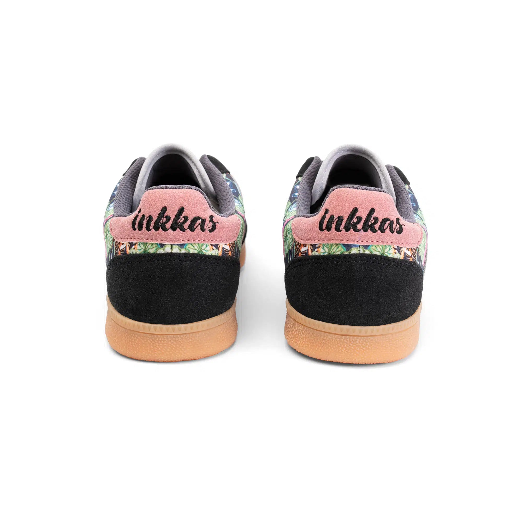 A pair of Inkkas low-top sneakers shown from the back, featuring a black suede heel, pink heel tab with black script logo, and a colorful tropical floral pattern on the sides, finished with a tan rubber sole.