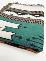 Woven blanket with geometric pattern on a white background