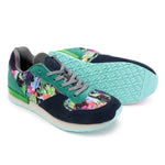 A pair of low-top sneakers shown on a white background, with one shoe standing upright and the other lying on its side to display the sole. The shoes feature a dark navy suede upper, teal green overlays, a colorful abstract graphic print on the toe and side panels, gray laces, and a light aqua sole.