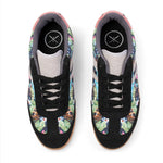 A pair of low-top sneakers shown from a top-down view on a white background. The shoes feature a black suede-like upper with tropical floral and tiger-print panels in green, orange, blue, and pink, black laces, and a light gray tongue.
