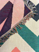 Close-up of a geometric patterned fabric with colorful fringes.