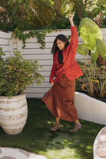 Girl in red outfit twirling in the grass